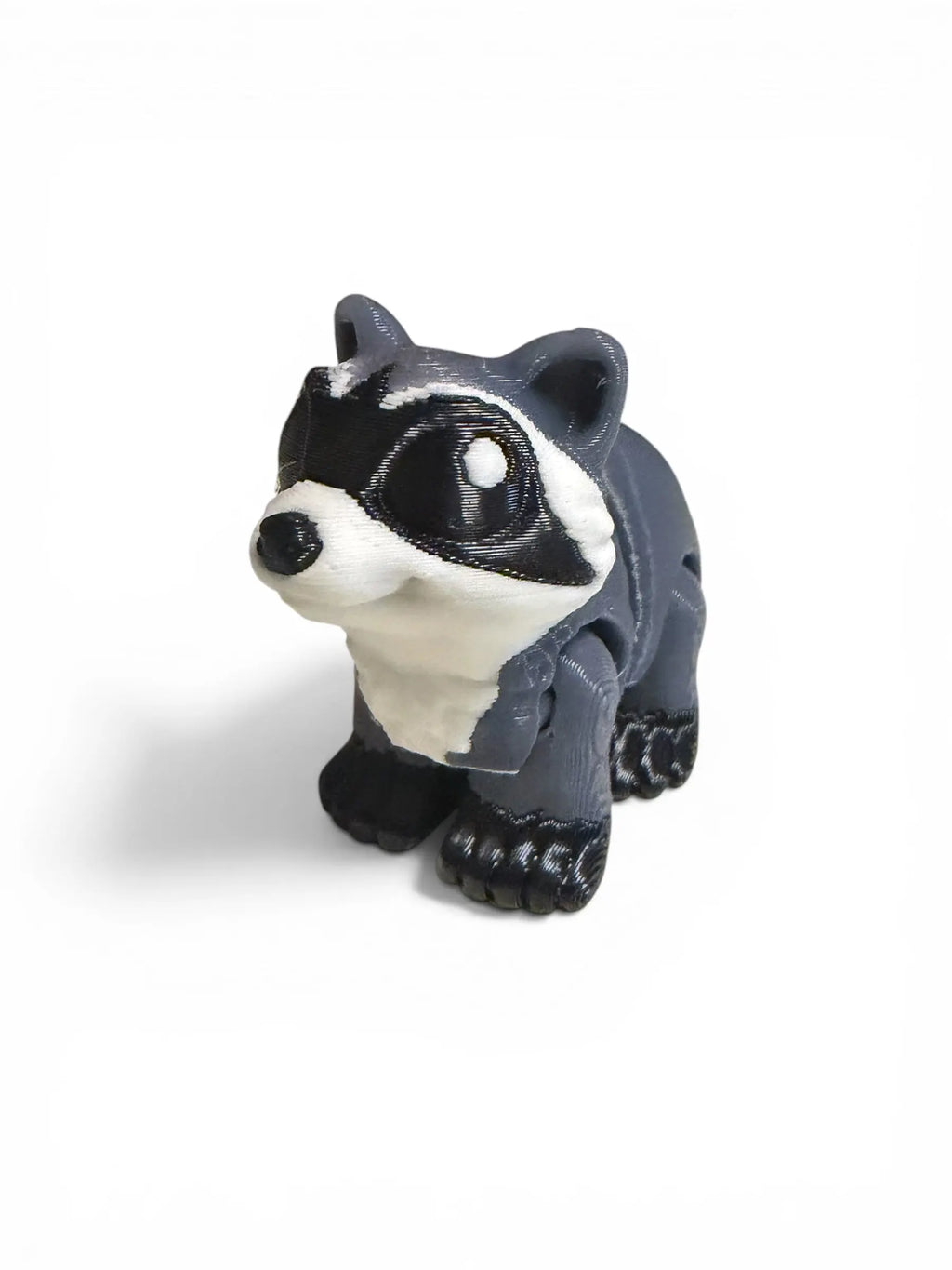 Small figurine of a raccoon on a white background