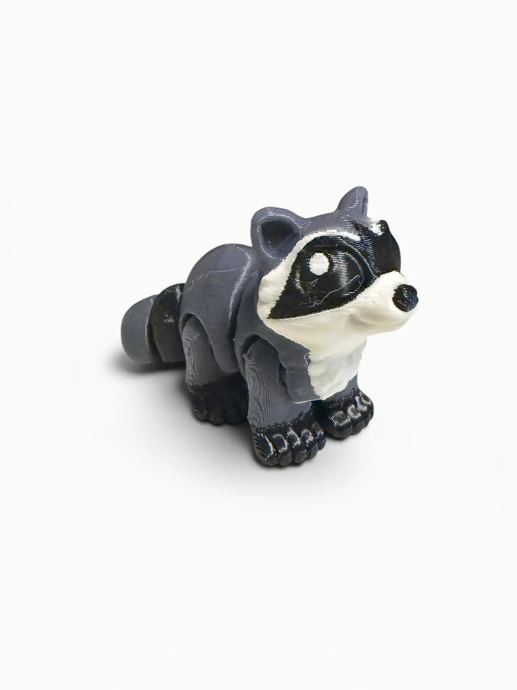 Small raccoon figurine on a white background