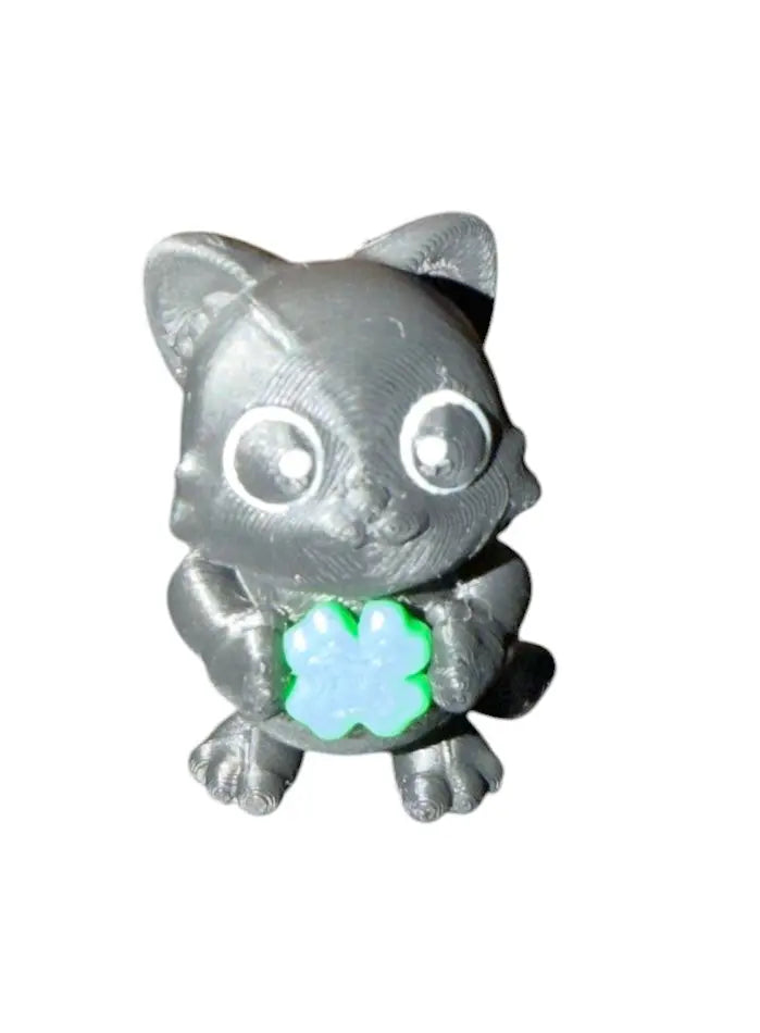 Black cat figurine with a  green shamrock on a white background