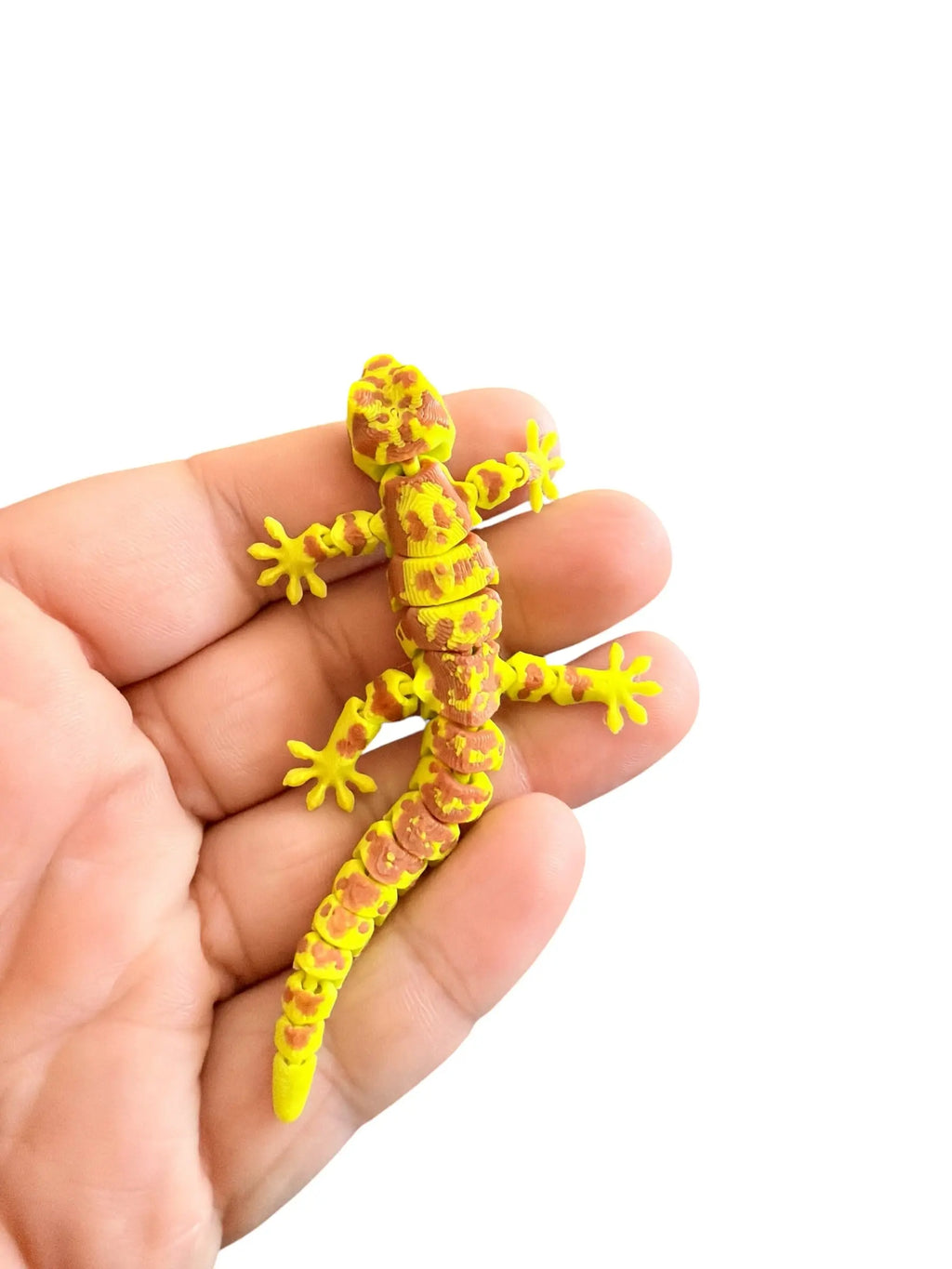 Green flexi gecko held in a hand against a white background