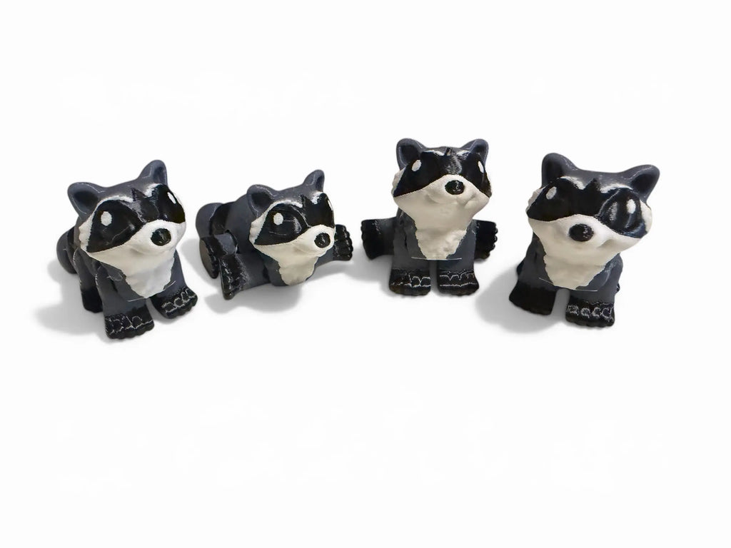 Four raccoon figurines in different poses on a white background