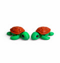 Flexi turtle with green body and brown shell on a white background