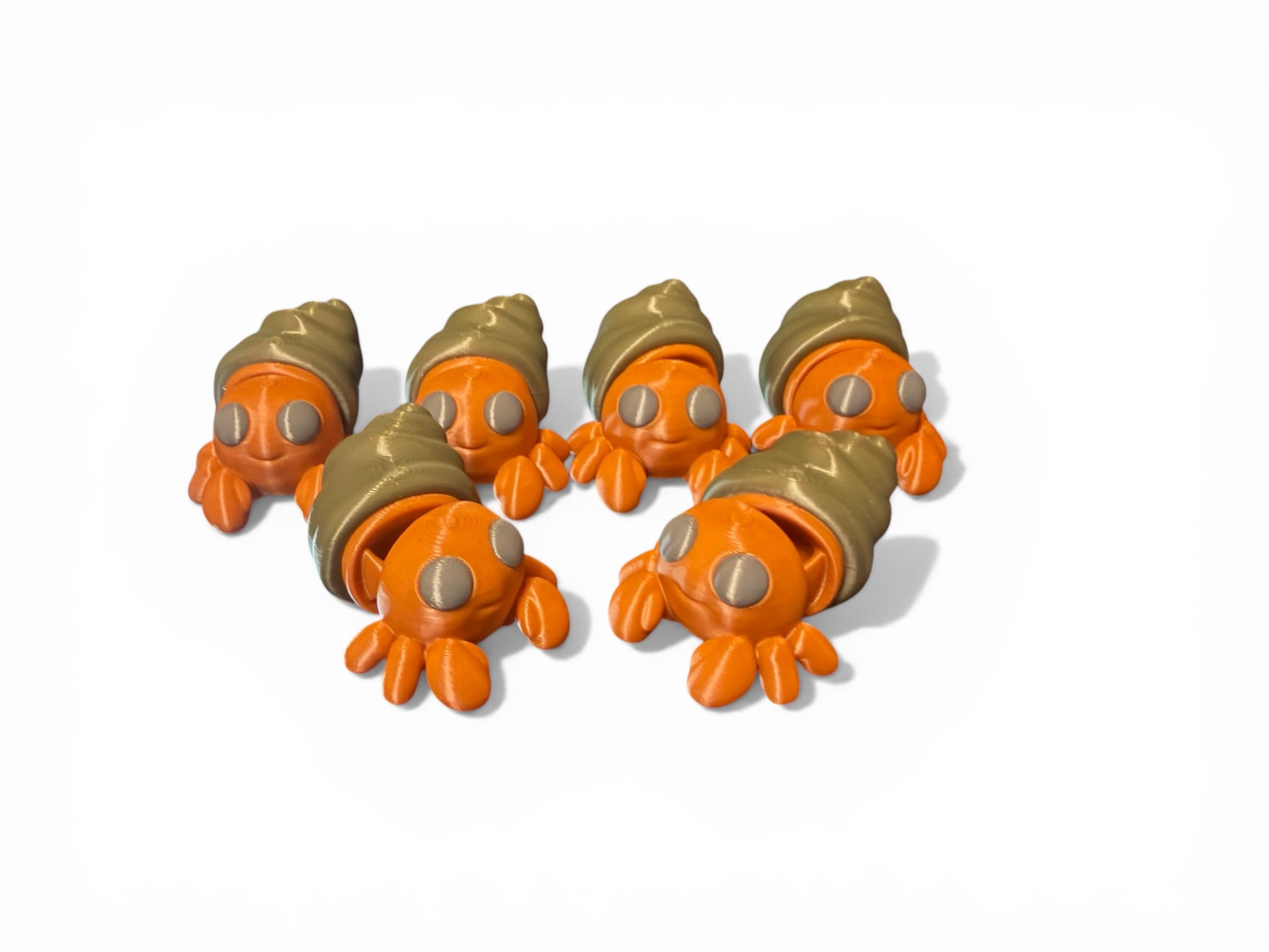 Five small orange and green toy hermit crabs on a white background